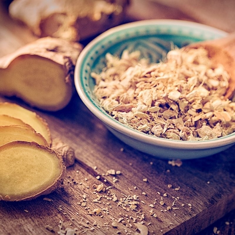 dried ginger roots in a bowl with fresh ginger on the table