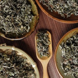 mugwort leaves on plates and in a wooden dispenser