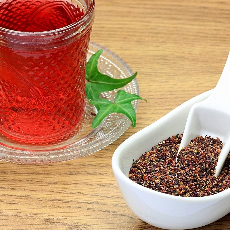 fragmented rose hips in a dispenser next to a tea