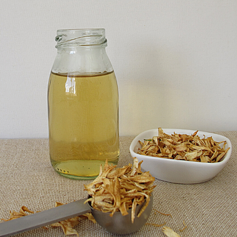 dried orange blossoms in a bowl and on the table, next to tea in a glass jar dried orange blossoms in a bowl and on the table, next to tea in a glass jar
