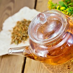 Tutsan tea in a teapot, and in the form of a dry and fresh herb