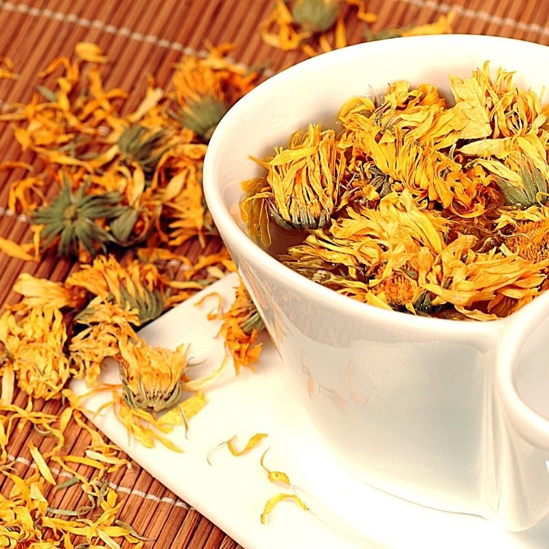 marigold flowers in a cup and on the table.