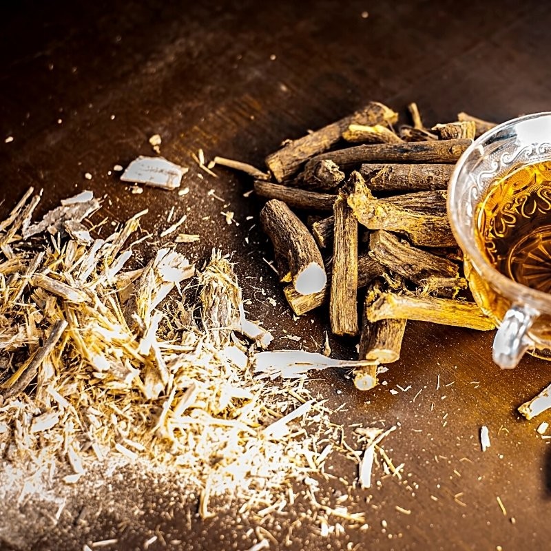 dried licorice roots on the table and in tea dried licorice roots on the table and in tea