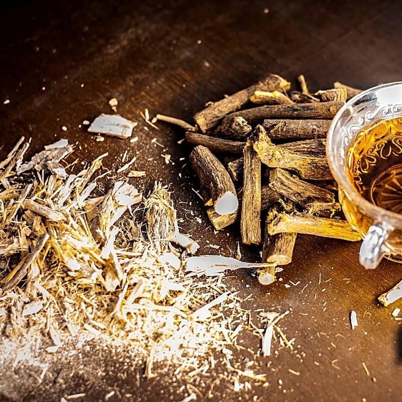 dried licorice roots on the table and in tea